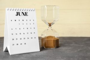 Flip paper calendar with hourglass on table