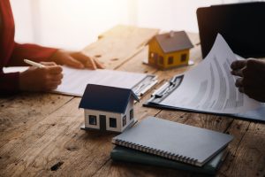 Real estate broker agent presenting and consult to customer to decision making sign insurance form agreement, buy and sell home model, concerning mortgage loan offer for and house insurance