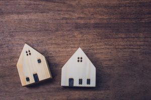 Miniature wooden houses on brown background with copy space
